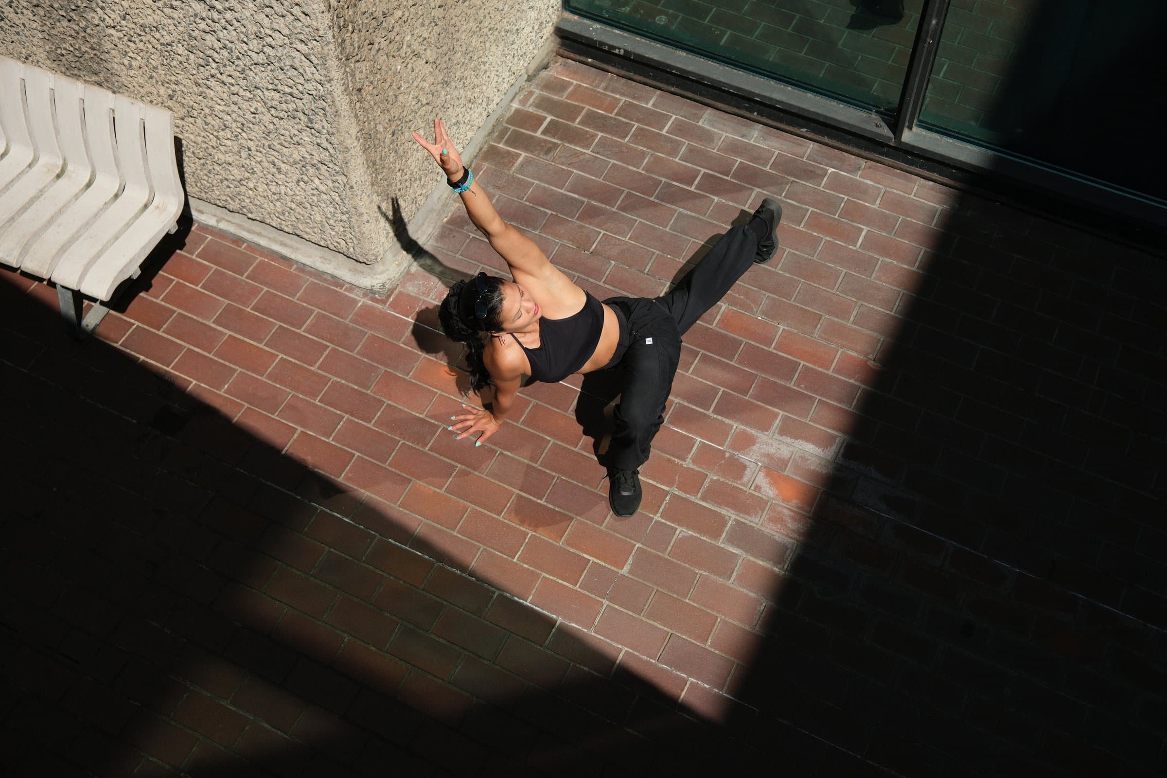 Karen in a deep side lunge on the Barbican bricks, seen from above
