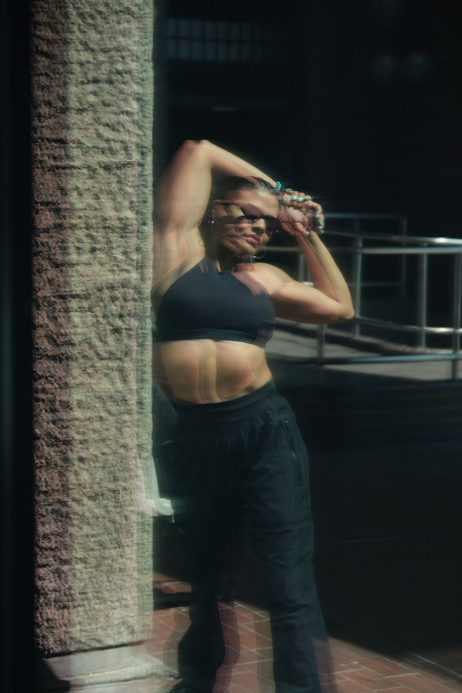 Karen against a brick wall, hand on her head