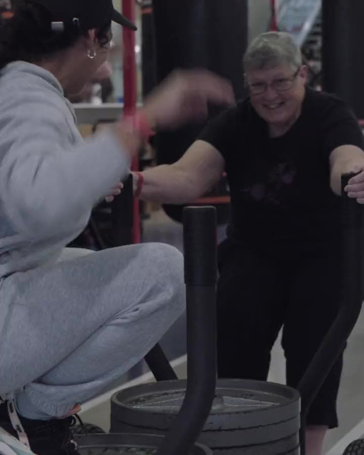 Karen coaching a client on a sled push